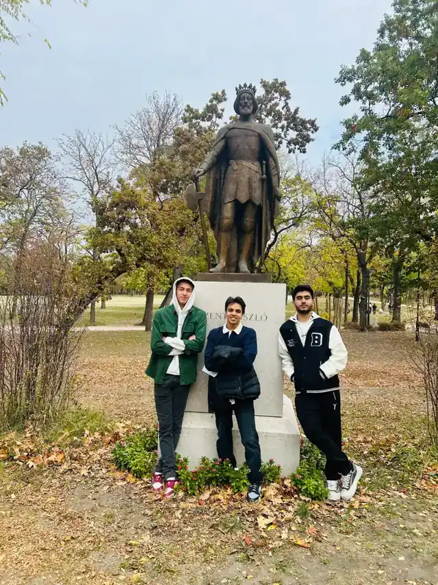 Three AIC students beside the Szent László statue in Orczy Park.